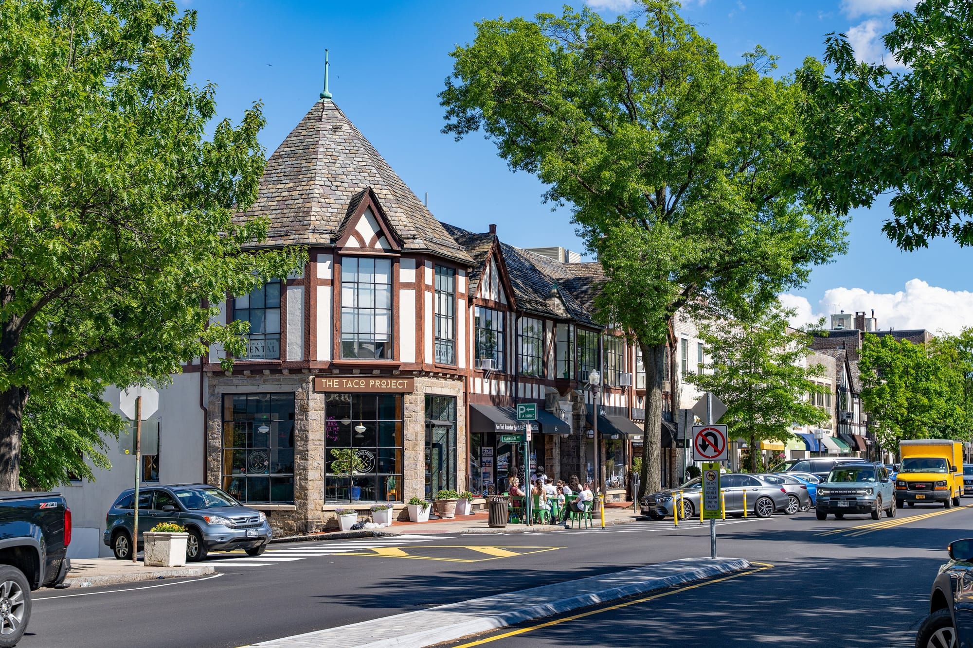 Tudor-style storefronts on a sunny shopping street in downtown Bronxville