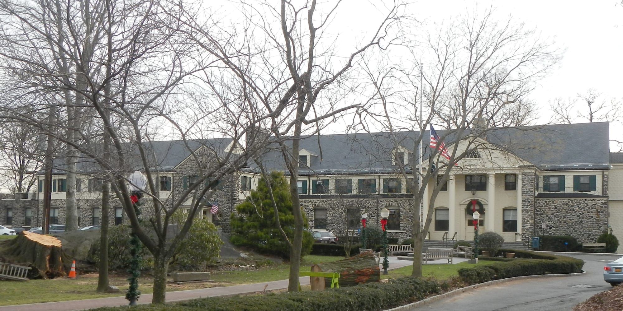 Eastchester Town Hall, a stone building with white columns behind bare trees