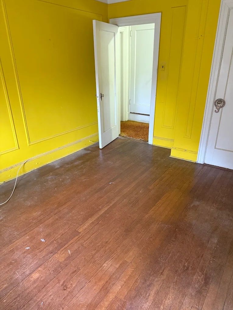 Empty yellow room with hardwood floors left clear after an estate cleanout