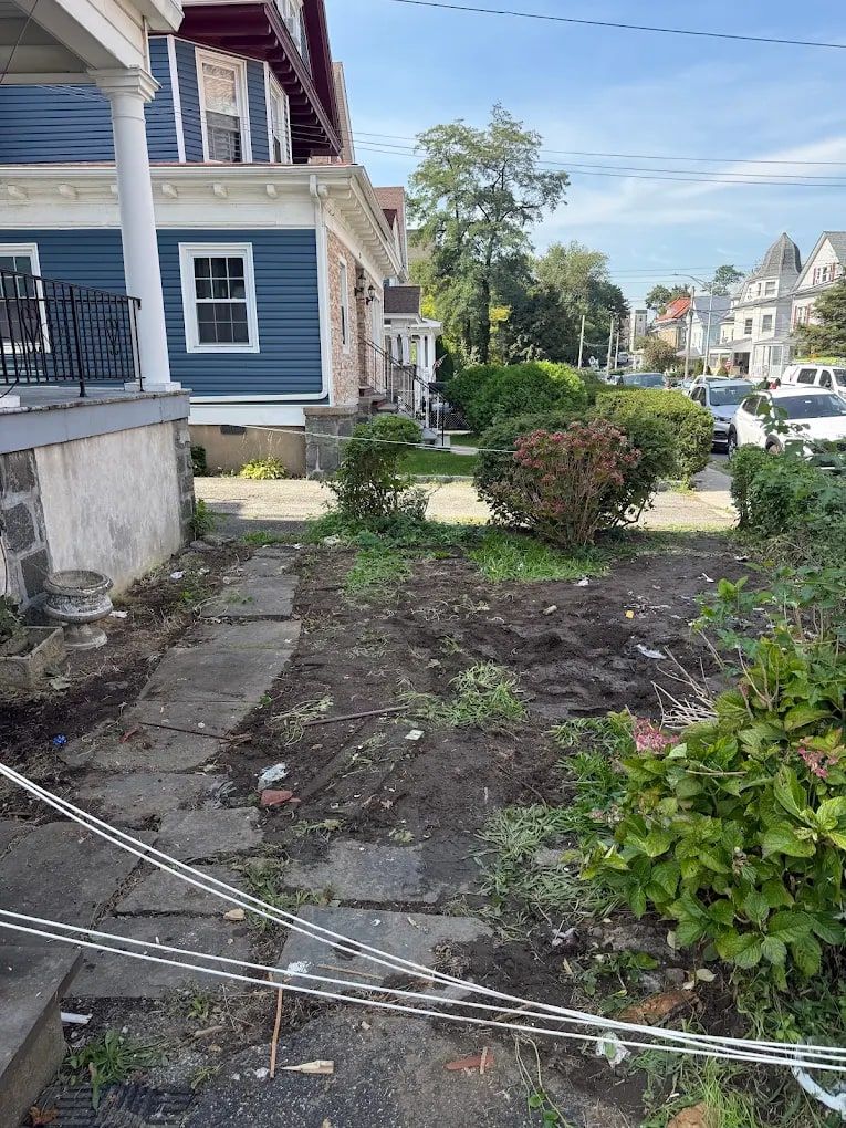 Front yard and walkway of a house cleared down to bare soil after yard debris removal