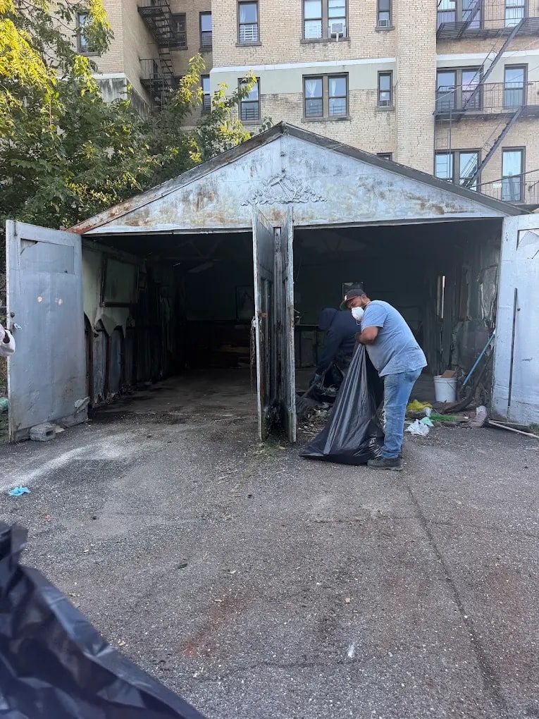 After the garage cleanout by Mitzvah Movers & Junk Removal: the same garage cleared, last debris being bagged