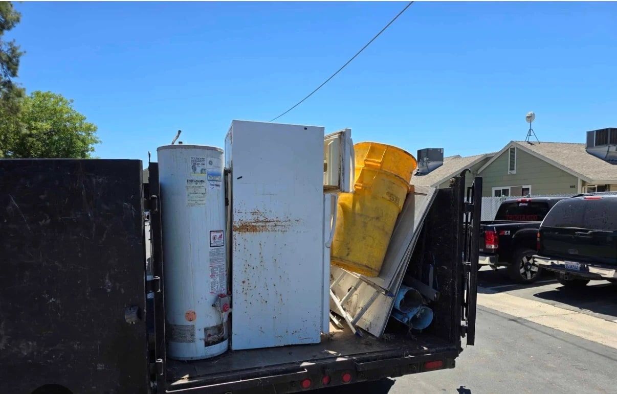 Water heater and refrigerator loaded in a truck bed for appliance removal